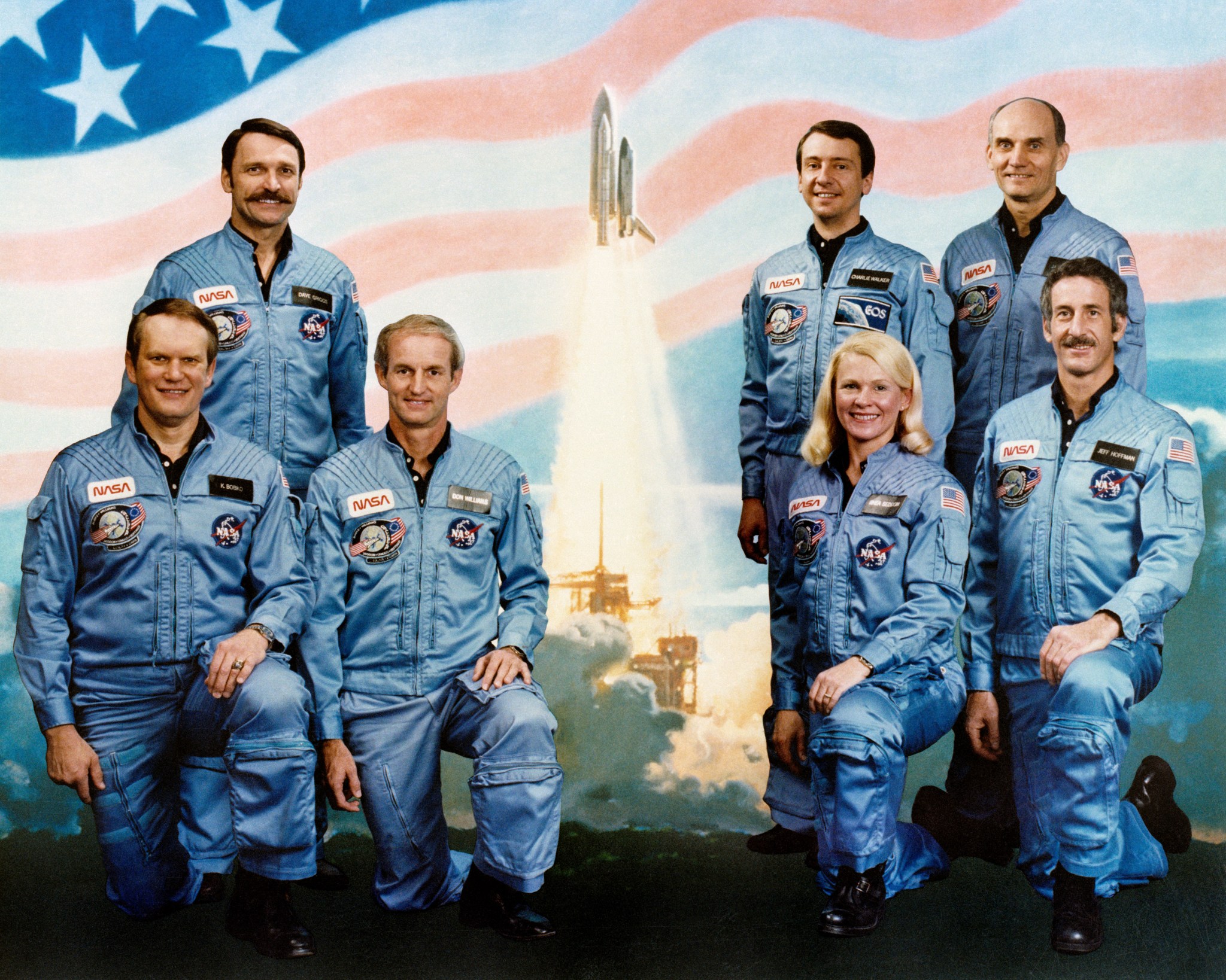 STS-51D Crew Portrait with U.S. flag in the background and an image of a shuttle launch.