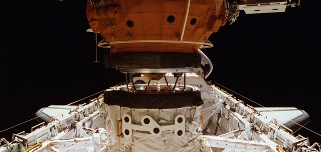 Payload bay view of Androgynous Peripheral Assembly System (APAS) of the Orbiter Docking System (ODS) connected to Mir Space Station's Docking Module.