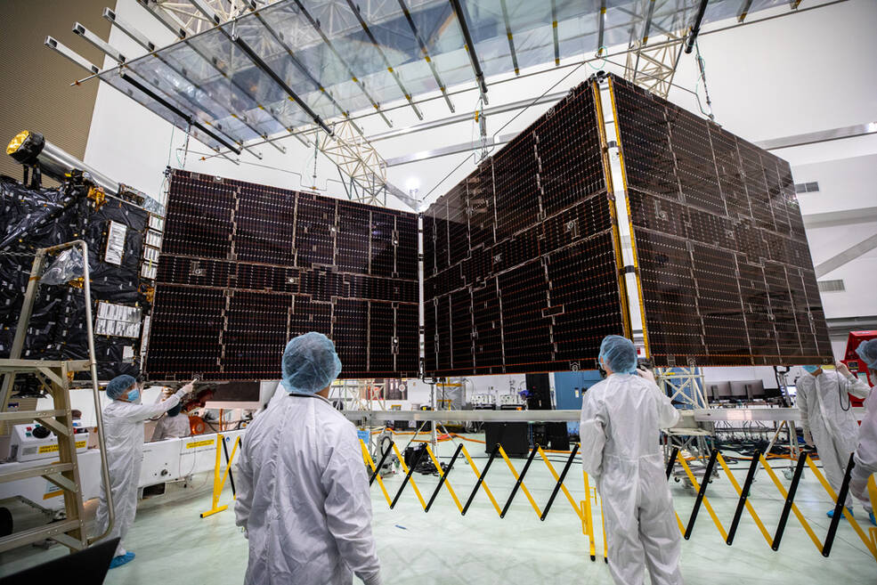 Technicians begin to retract one of the two solar arrays