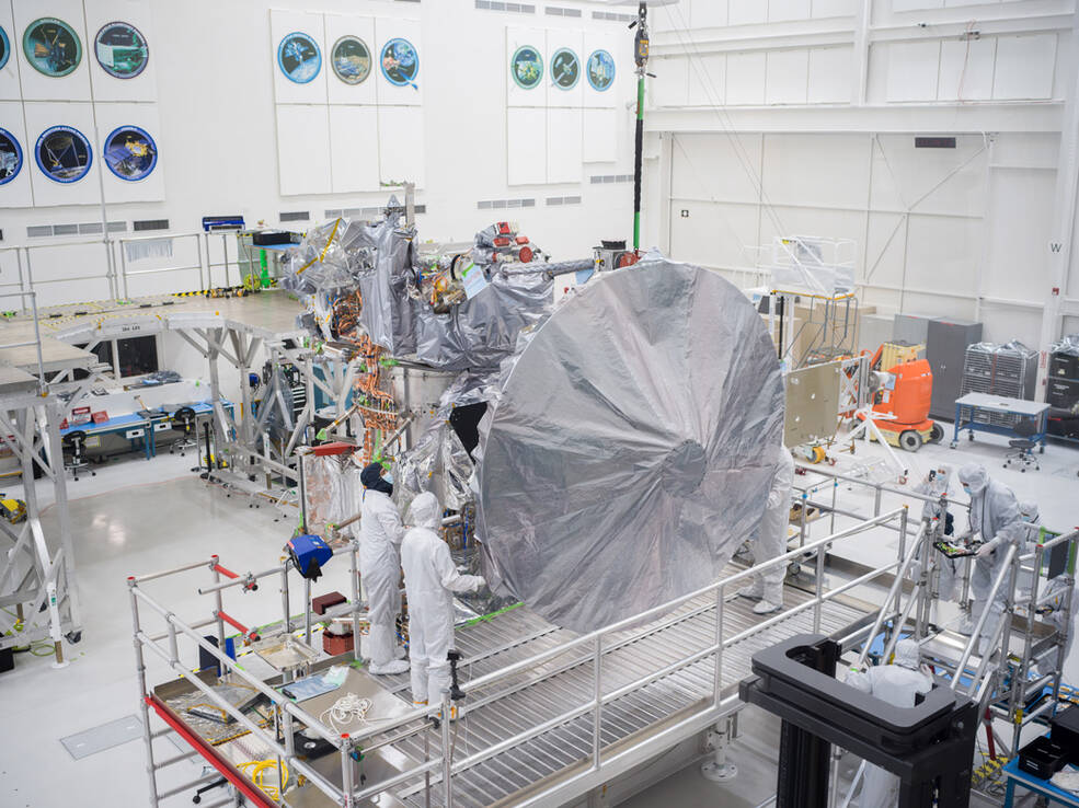 Engineers and technicians install Europa Clippers high-gain antenna in the main clean room at JPL.