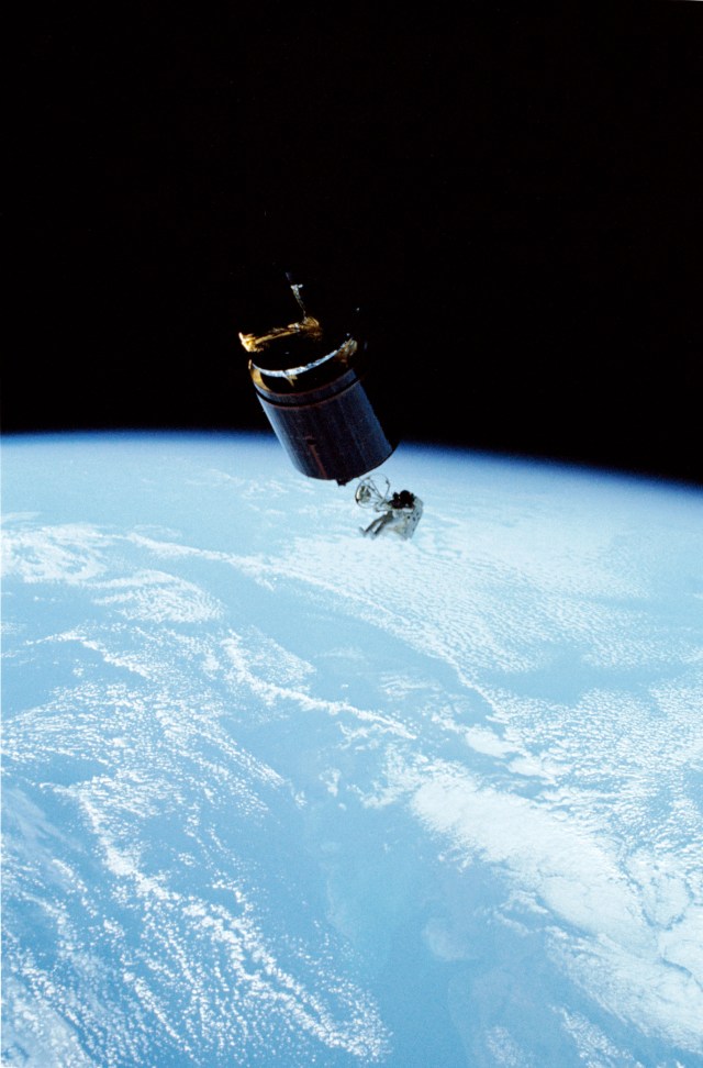 Mission Specialist (MS) Dale A. Gardner, wearing an Extravehicular Mobility Unit (EMU), using the Manned Maneuvering Unit (MMU) to travel to the Westar VI satellite.