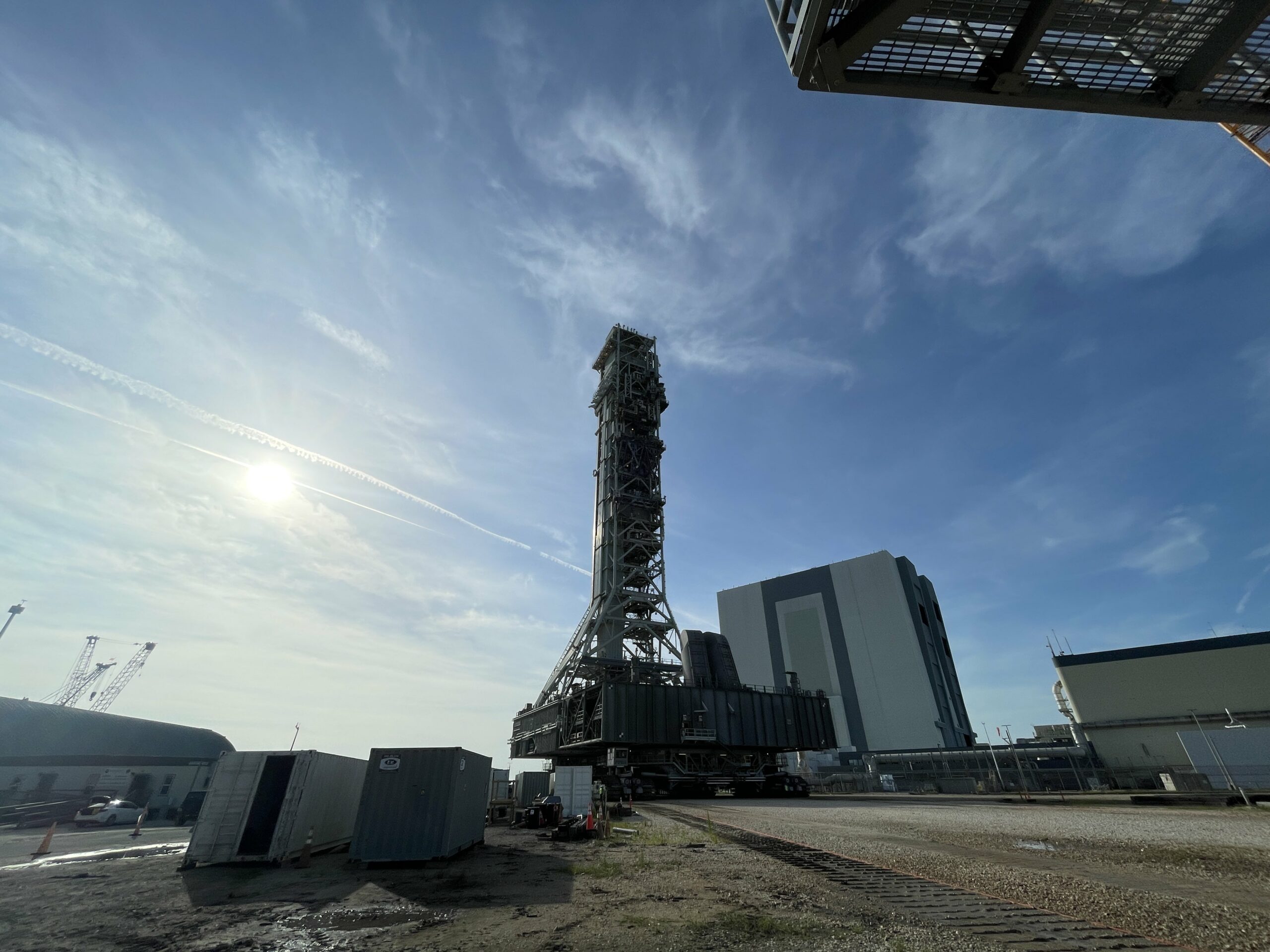 Under bright blue skies, the mobile launcher 1 is seen behind the Vehicle Assembly Building at NASA's Kennedy Space Center in Florida on Aug. 16, 2023 as it gets ready to roll to Launch Pad 39B.