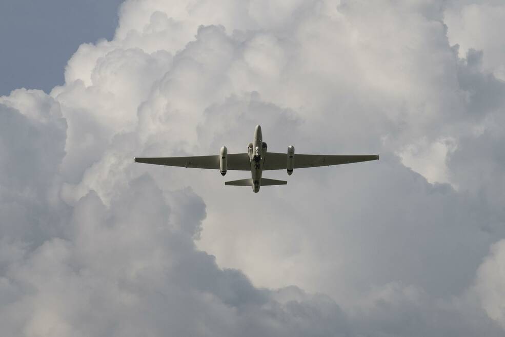 NASAs ER-2 aircraft flying overhead through brewing thunderclouds off the Floridian coast.