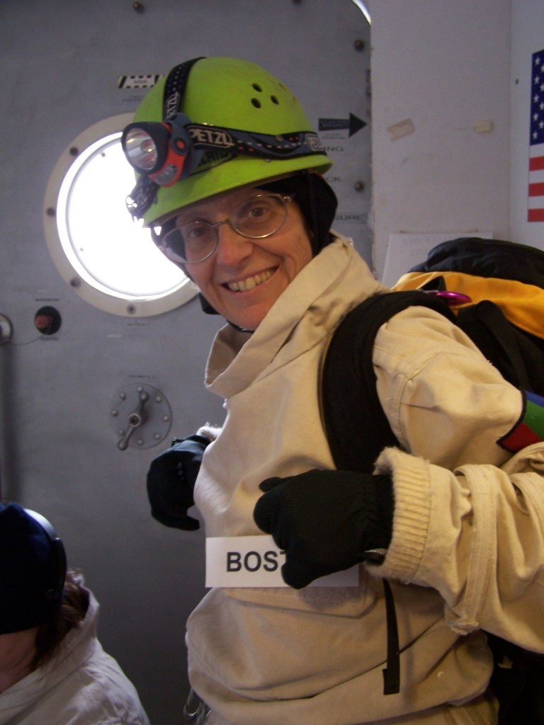 Astrobiologist Penny Boston smiles to the camera while wearing caving protective gear while preparing for an excursion.