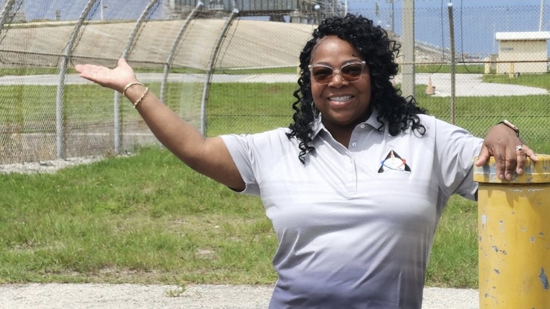 Macresia Alibaruho, a leader in the program management office for NASA’s Human Research Program, stands in front of NASA’s Artemis rocket and launch pad at Kennedy Space Center in Florida.