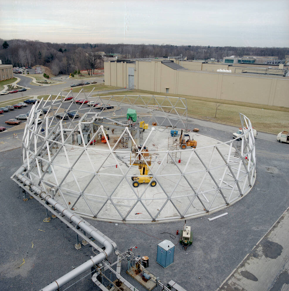 An overhead shot of construction equipment and partially built triangular frame segments for the dome for NASA Glenns Aero-Acoustic Propulsion facility.