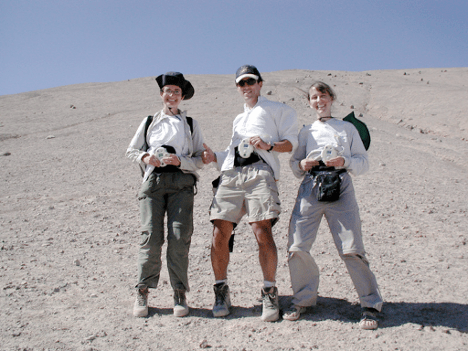 Three people standing in the desert wearing safari clothing for the Stanford-ARC CPOD (Crew Physiologic Observation Device) hardware