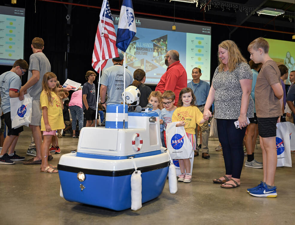 Coastie the Safety Boat, the Coast Guard Auxillarys robotic talking boat, prompts smiles and curiosity at Take Our Children to Work Day.