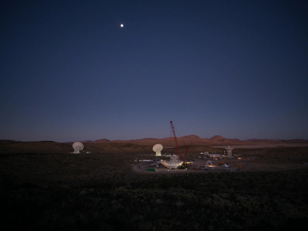 In the early morning of Dec. 18, 2024, a crane looms over the 112-foot-wide (34-meter-wide) steel framework for Deep Space Station 23 reflector dish, which will soon be lowered into position on the antenna’s base structure.