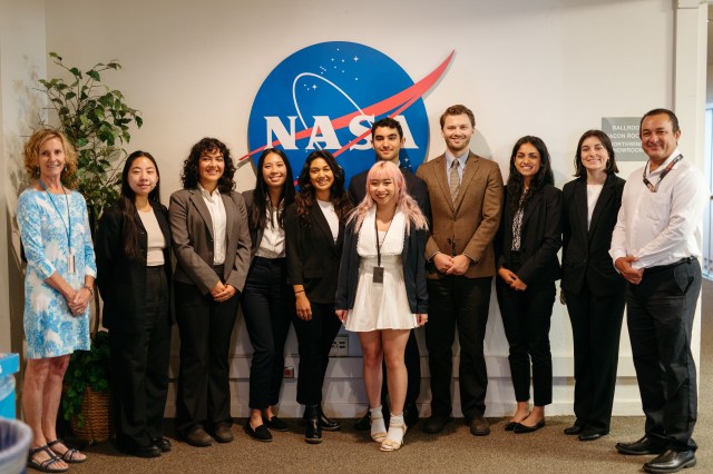 The DEVELOP summer 2023 class poses in front of a NASA sign.
