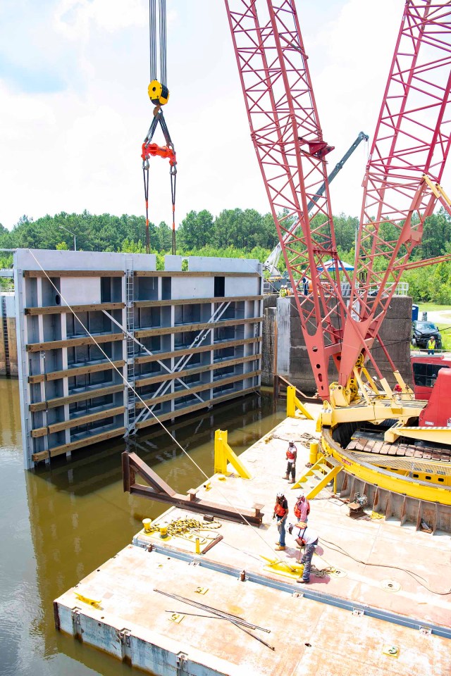 Crews positioning the final refurbished miter gate into place on the lock system