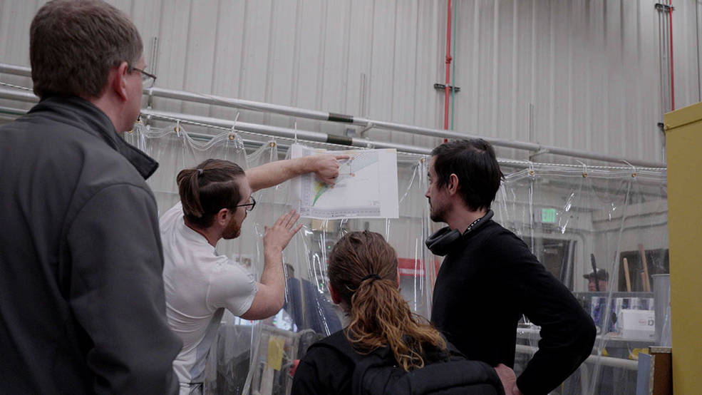 JPL engineer Patrick DeGrosse reviews data from a footpad test with a group of fellow engineers