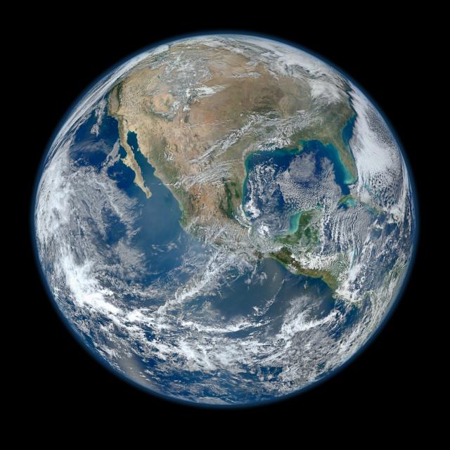 A view of the Earth from space, with the continent of North America clearly visible through swirling clouds.