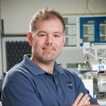 Portrait of Danny Glavin wearing a blue collared shirt.