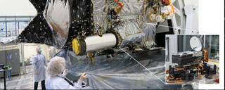The Deep Space Optical Communications (DSOC) flight transceiver is inside a large tube-like sunshade and telescope on the Psyche spacecraft, as seen here inside a clean room at JPL.