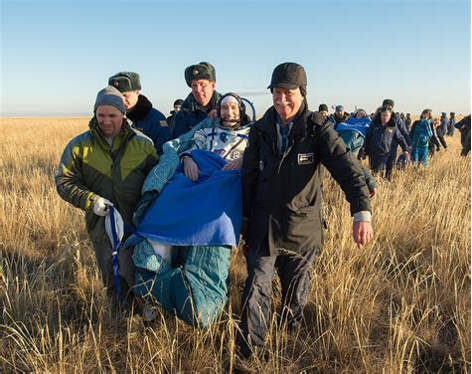 Astronauts being held by their teams after landing back on Earth