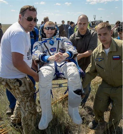 Astronauts being held by their teams after landing back on Earth