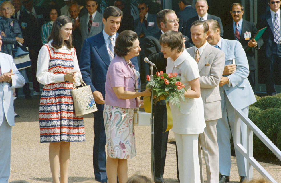 Dee O’Hara presents a bouquet of flowers to Mrs. Johnson 