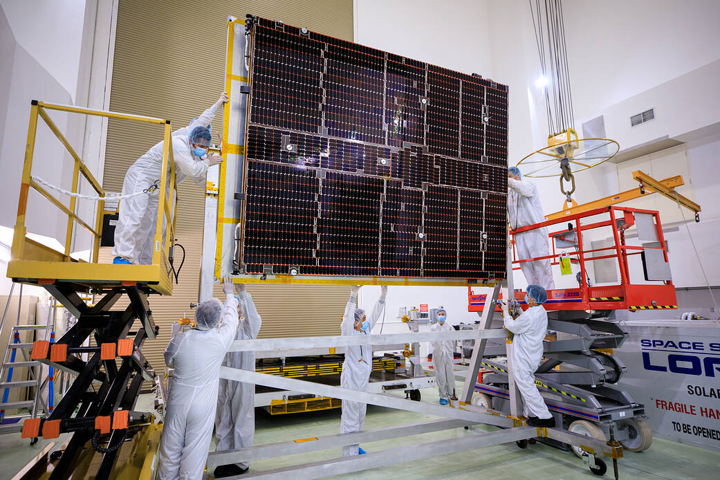 A NASA team helps attach solar arrays for the agency’s Psyche spacecraft onto a stand inside the Astrotech Space Operations Facility near the agency’s Kennedy Space Center in Florida on July 18, 2023.