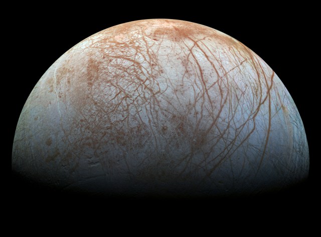 Europa, a moon of Jupiter, appears as a thick crescent in this enhanced-color image from NASA's Galileo spacecraft, which has been orbiting Jupiter since 1995.