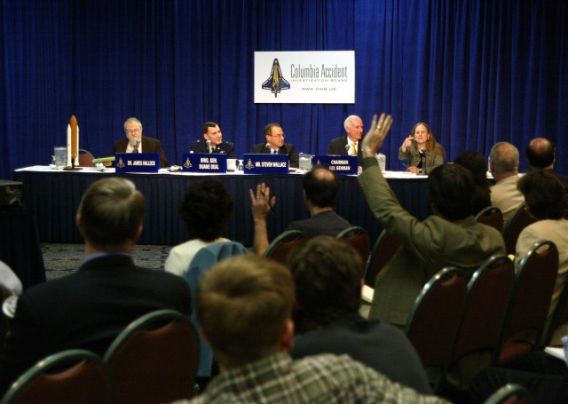 Reports raise their hands to ask questions of the CAIB panel during a press briefing.