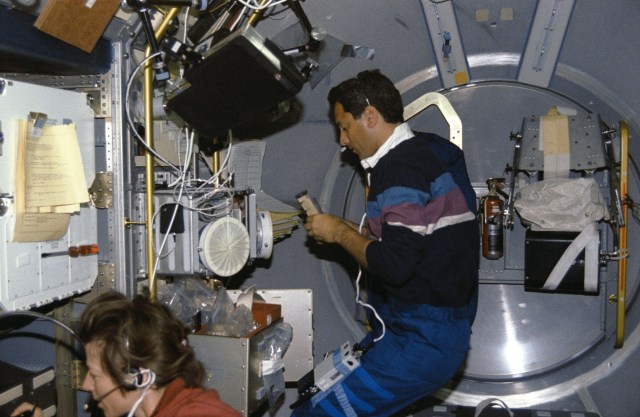 Mission Specialist Bonnie Dunbar and Payload Specialist Lawrence DeLucas in the spacelab with the Generic Bioprocessing Apparatus, rack #10.