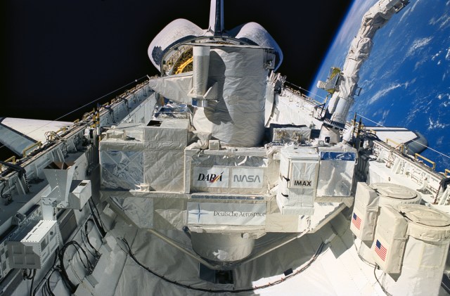 Backdropped against black space and the blue and white Earth, the Orbiting Retrievable Ultraviolet Spectrometer (ORFEUS) and its Shuttle Pallet Satellite (SPAS) are pictured during berthing in Discovery's cargo bay.
