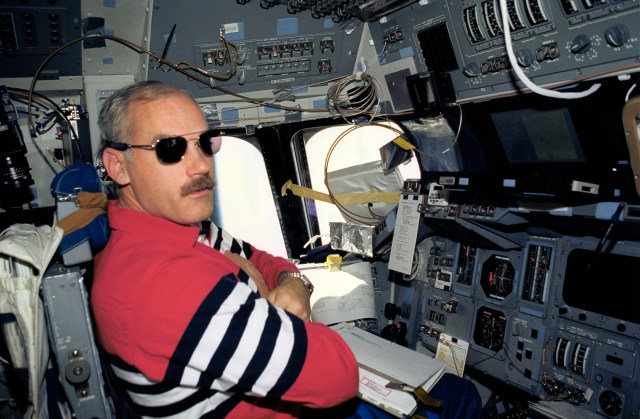 On Discovery's forward flight deck, Astronaut William F. Readdy, pilot, wears shades to block out bright sunshine. Much of the sunshine that normally would be coming through forward windows is blocked by an array of portable computers