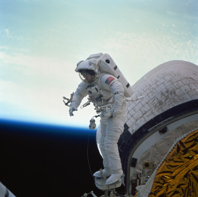 Astronaut James H. Newman, mission specialist, conducts an in-space evaluation of the portable foot restraint (PFR) which will be used operationally on the first Hubble Space Telescope (HST) servicing mission and future Shuttle missions