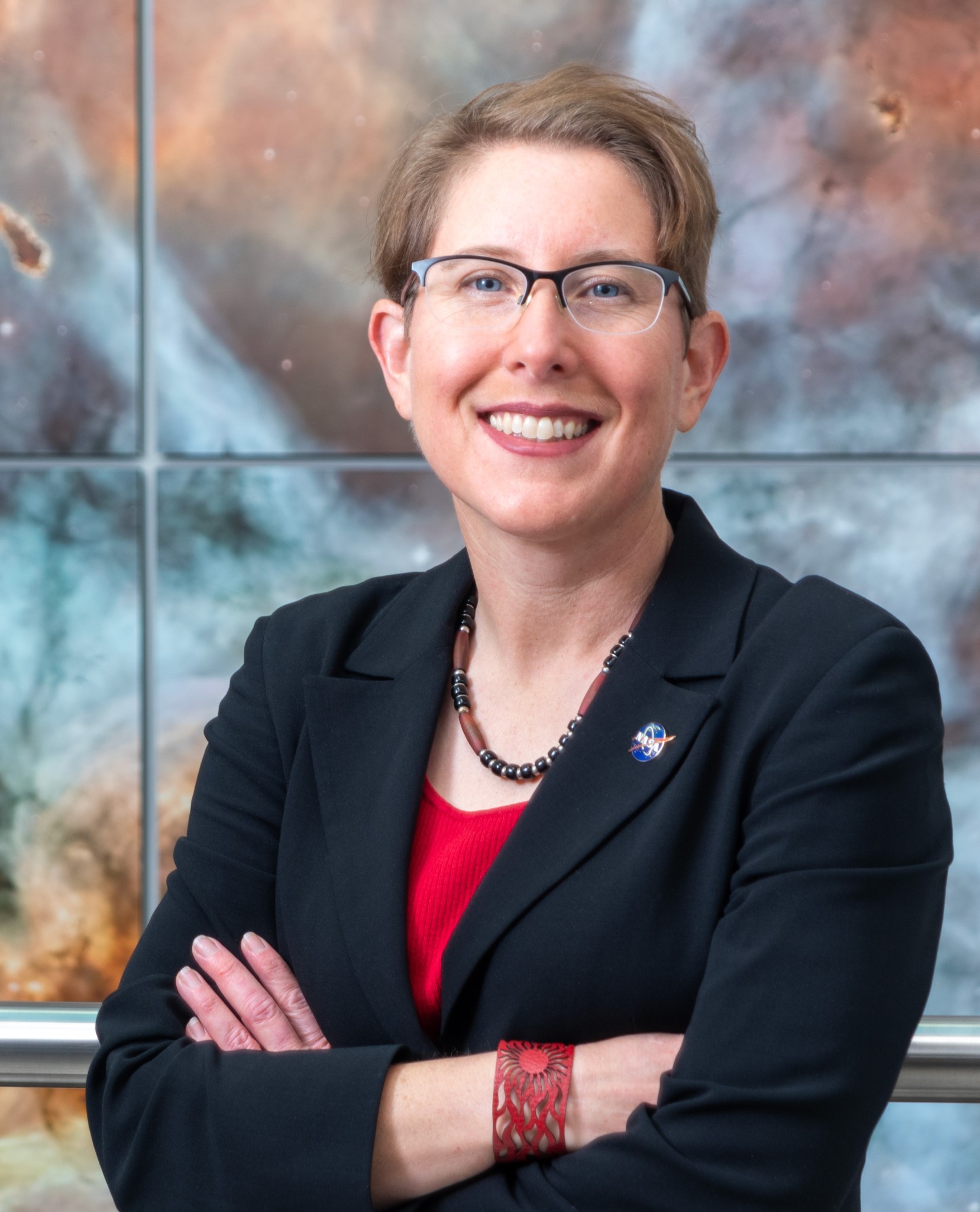 Portrait of Dr Jane Rigby Senior Project Scientist for the James Webb Space Telescope cross faded with a Webb Telescope deep field image.