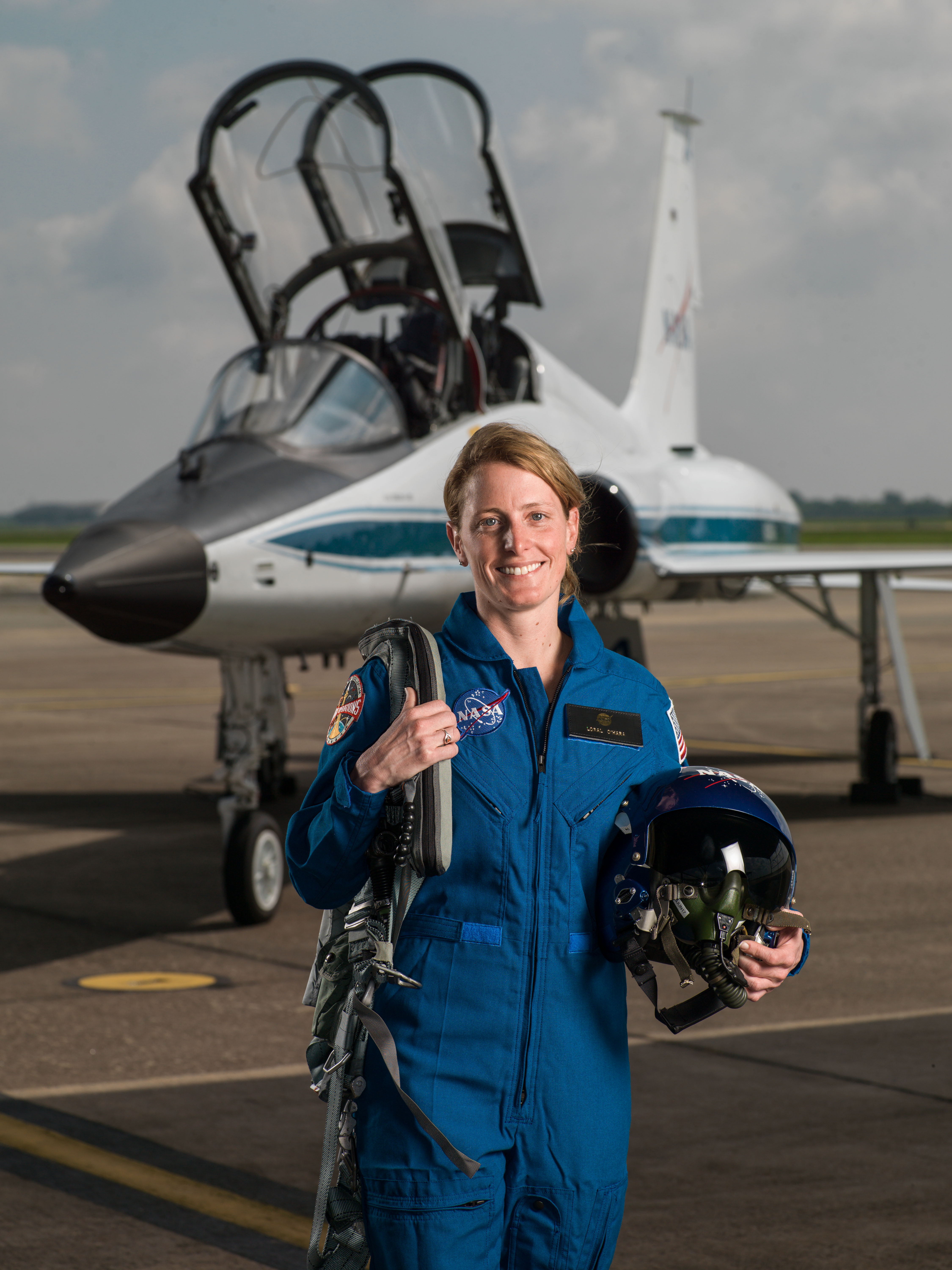 NASA portrait of 2017 Astronaut Candidate Loral O'Hara in front of a T-38 trainer aircraft at Ellington Field near NASA’s Johnson Space Center in Houston, Texas.