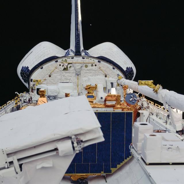 contents of the STS-41G orbiter Challenger's payload bay. Part of the Earth Radiation Budget Satellite (ERBS) and the Shuttle Imaging Radar-B (SIR-B) are visible in the frame.