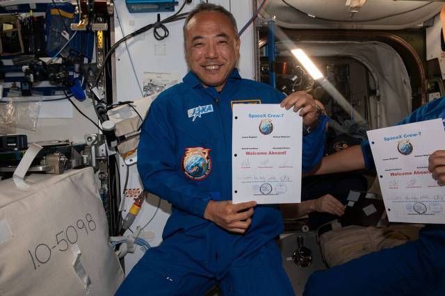 JAXA astronaut and Crew-7 Mission Specialist, Satoshi Furukawa, smiles for a photo while holding a welcome message from the Expedition 69 crew, following Crew-7's arrival to the International Space Station.
