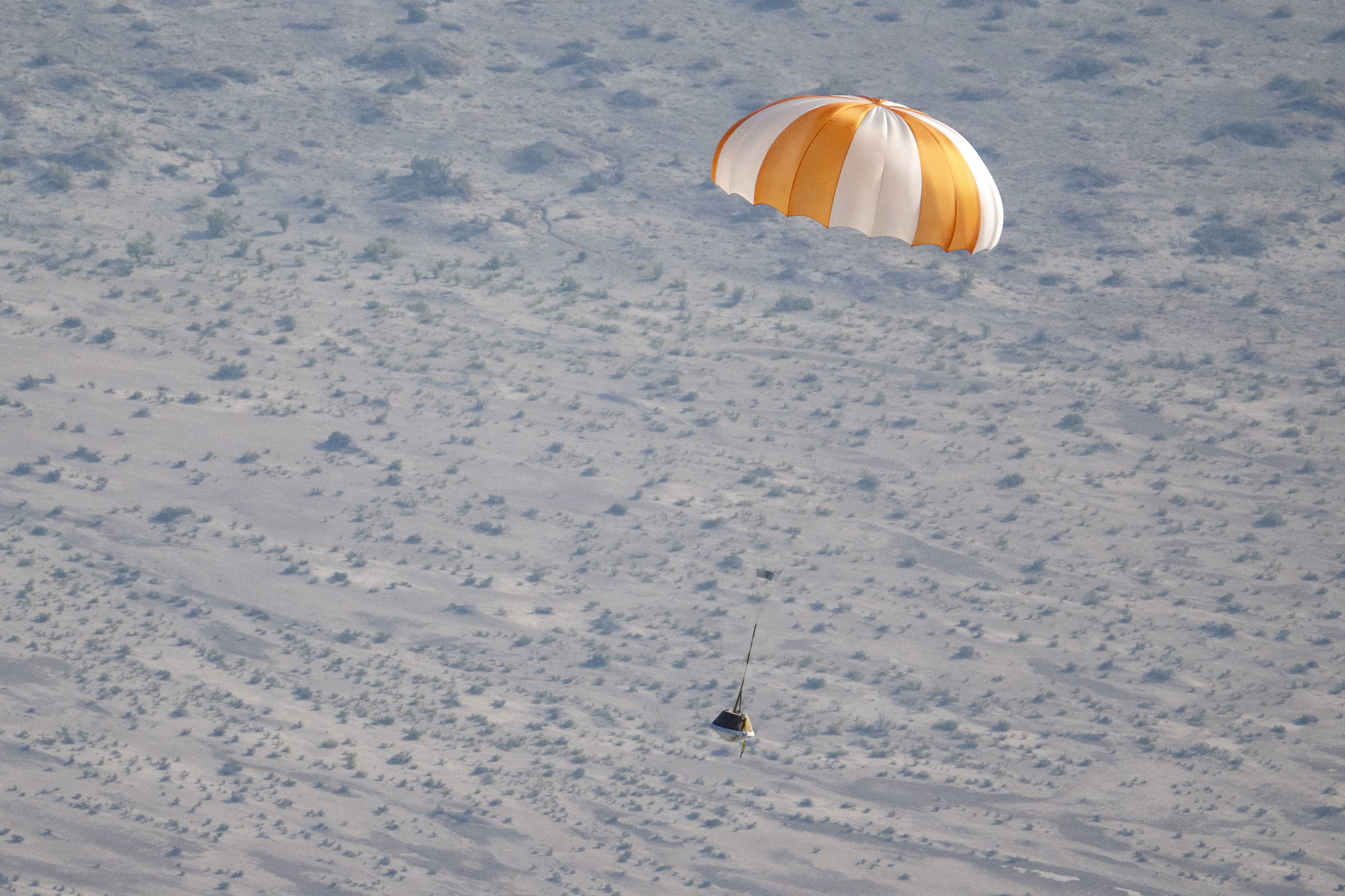 A training model of the sample return capsule during a drop test in preparation for the retrieval of the sample return capsule from NASA's OSIRIS-REx mission, Wednesday, Aug. 30, 2023, at the Department of Defense's Utah Test and Training Range.