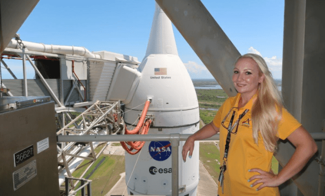 A photograph of Kennedy Space Center's Amanda Stevenson with the Orion capsule in the background.