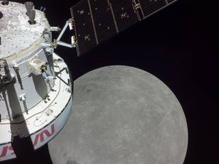 A portion of the far side of the Moon looms large just beyond the Orion spacecraft in this image taken on the sixth day of the Artemis I mission by a camera on the tip of one of Orion's solar arrays.