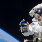 Astronaut holding phone with NASA app while on spacewalk