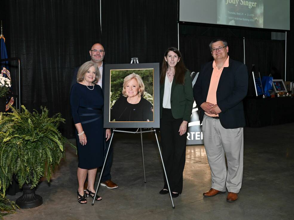 Singer, far left, stands next to a portrait of herself after its unveiling at her retirement ceremony Sept. 21.