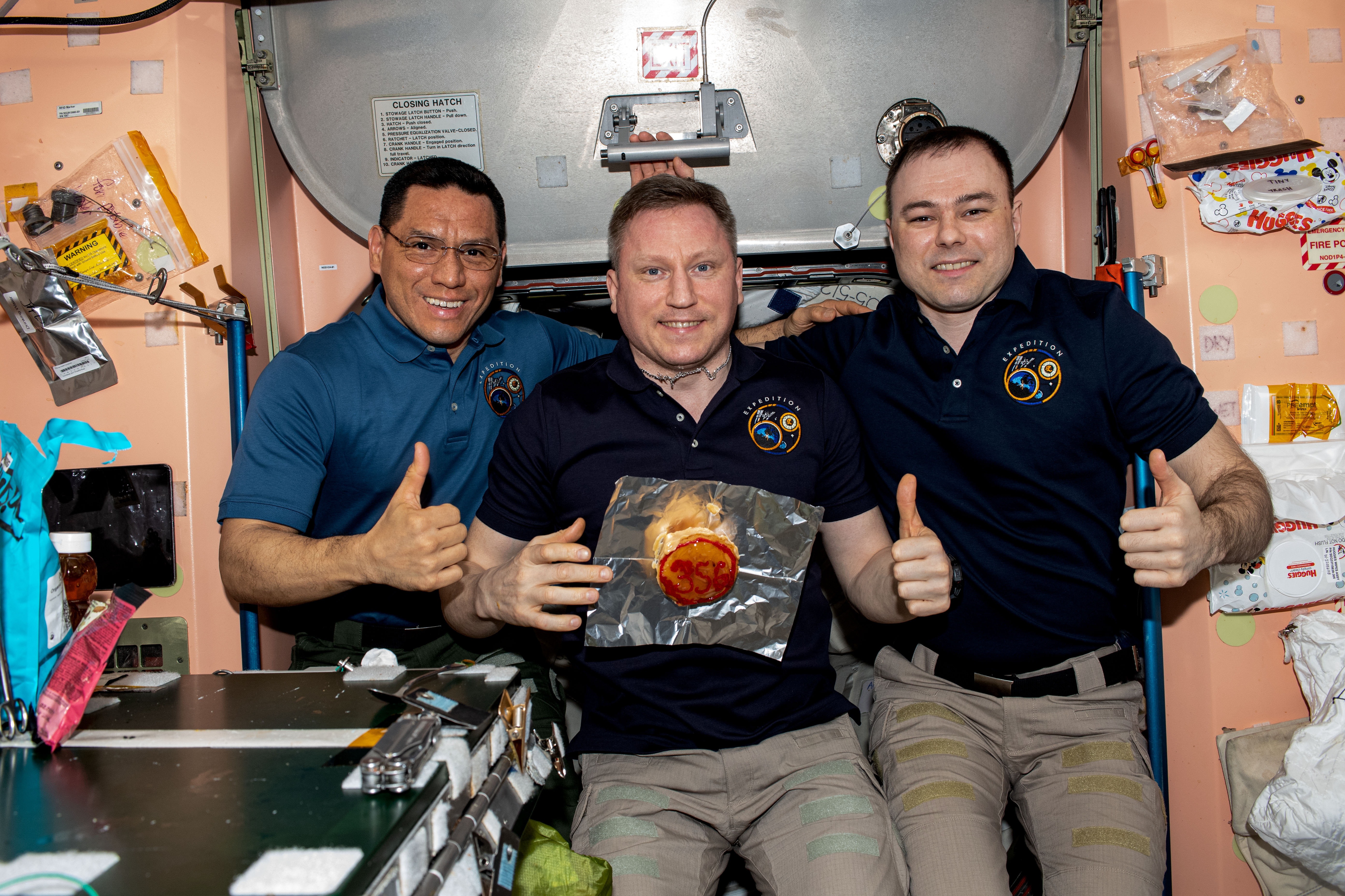 NASA astronaut Francisco “Frank” C. Rubio with Russian cosmonauts Sergey V. Prokopyev and Dmitri A. Petelin with a cake with “356” written on it to signify they surpassed the previous record
of 355 days as the longest flight aboard the space station.