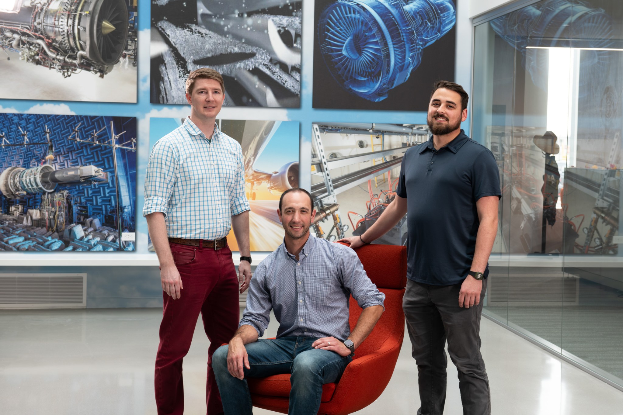 Three men pose for a photo in a lobby at NASA's Glenn Research Center.