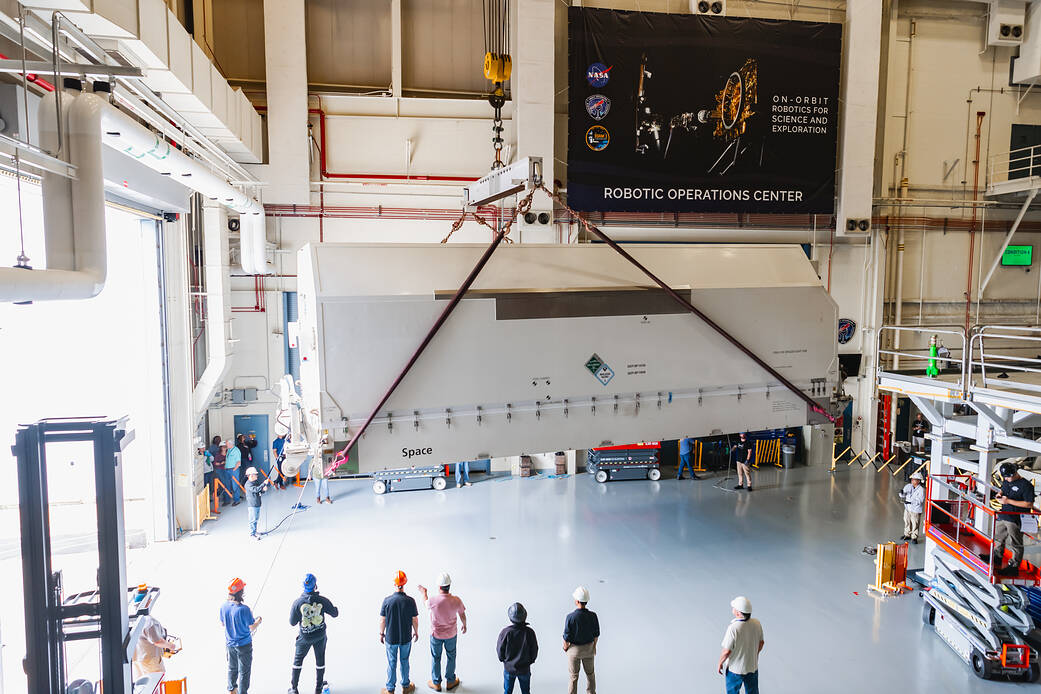 A container holding the spacecraft bus for the On-orbit Servicing, Assembly, and Manufacturing 1 (OSAM-1) mission is lifted by crane into the integration and testing complex at NASA's Goddard Space Flight Center in Greenbelt, Maryland.