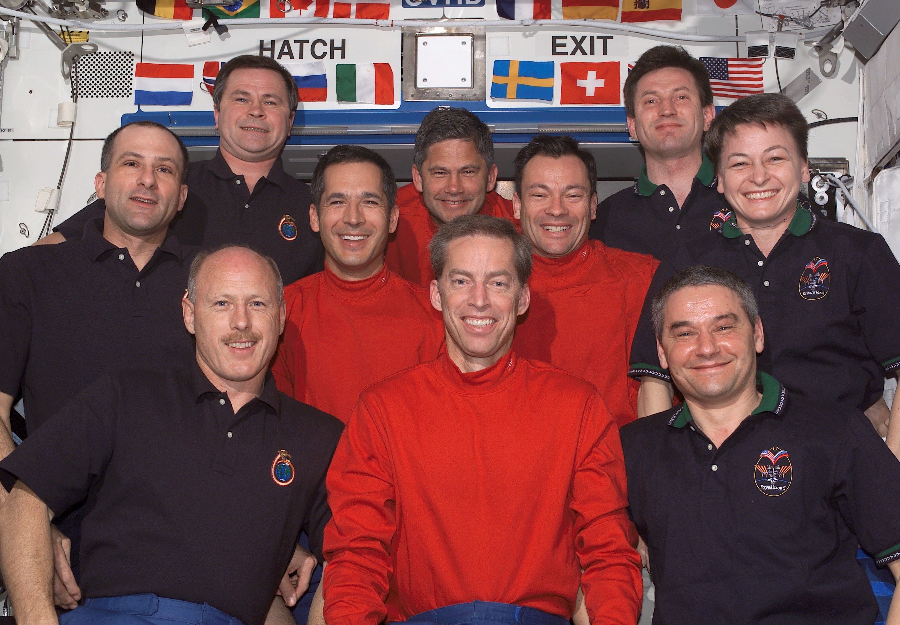 Lopez-Alegria, second from right in the middle row, posing in the Destiny module with his STS-113 crewmates, as well as the Expedition 5 and 6 crews