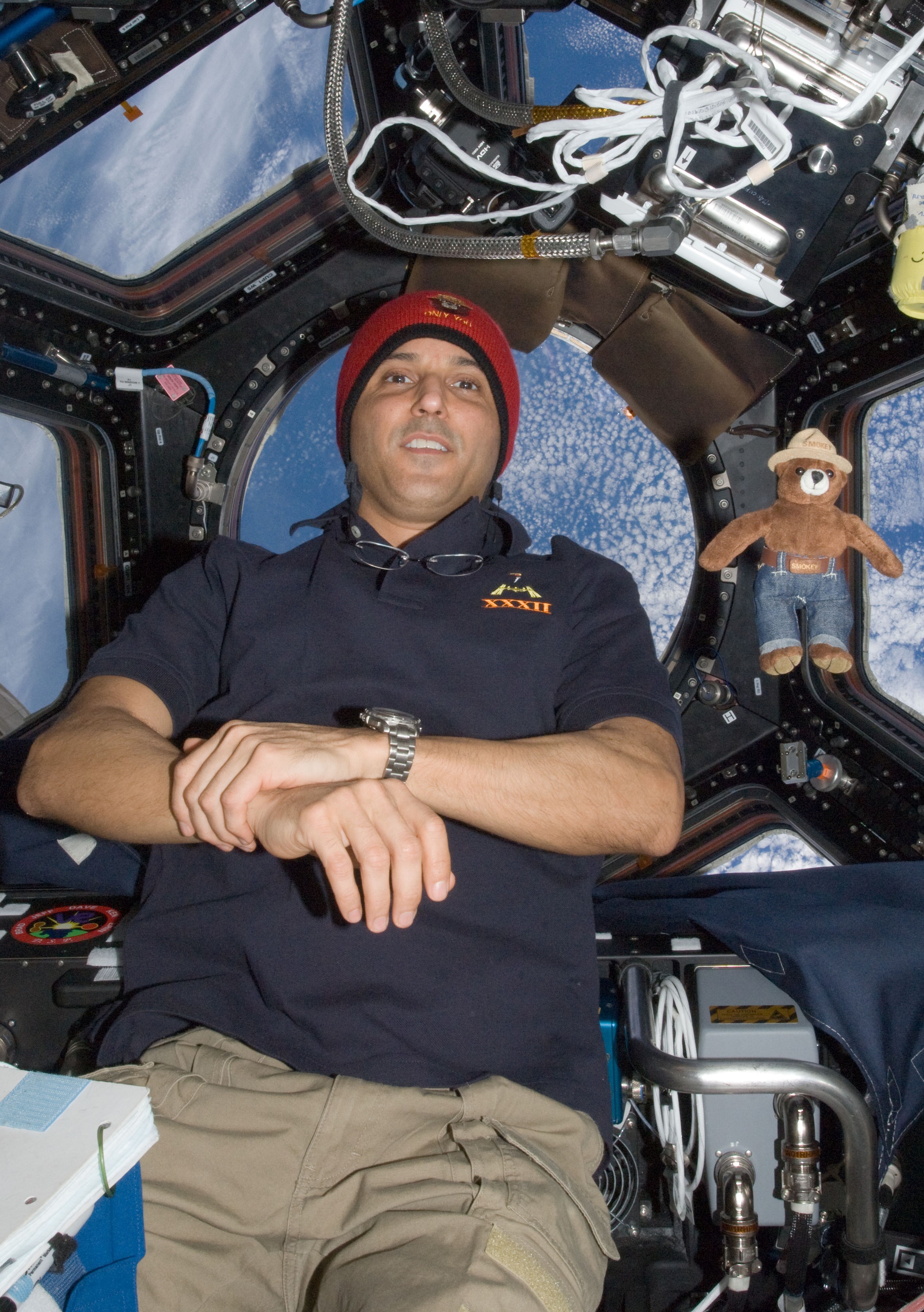 NASA astronaut Joseph M. Acaba with a toy Smokey the Bear in the Cupola to help celebrate the forest fire prevention icon’s 68th birthday