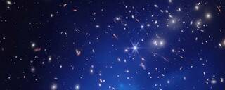 A field of distant galaxies and stars with a bright blue, cone-shaped cloud at its core. The cloud is superheated gas in the galaxy cluster known as u0022El Gordou0022
