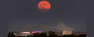 A Super Blue Moon rises above the Mississippi River and the Crescent City Connection Bridge in New Orleans, Aug. 30.