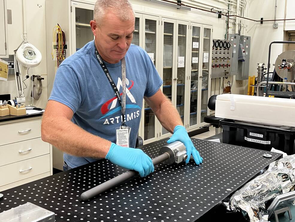 Chris Honea, a NASA Marshall Space Flight Center technician supporting payloads, unwraps a payload Aug. 18 for semiconductor research that recently arrived from the International Space Station. The experiment studied crystal growth in microgravity.