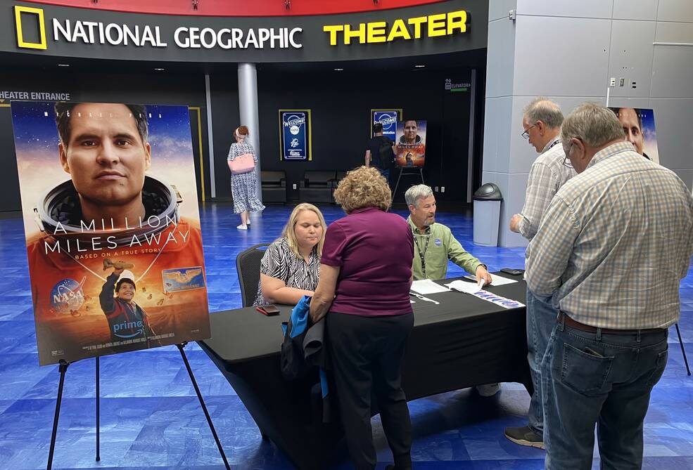 Marshall team members Amanda Dobbs, far left, and Todd Cannon, center, welcome attendees to a special film screening of A Million Miles Away at the U.S. Space & Rocket Center.
