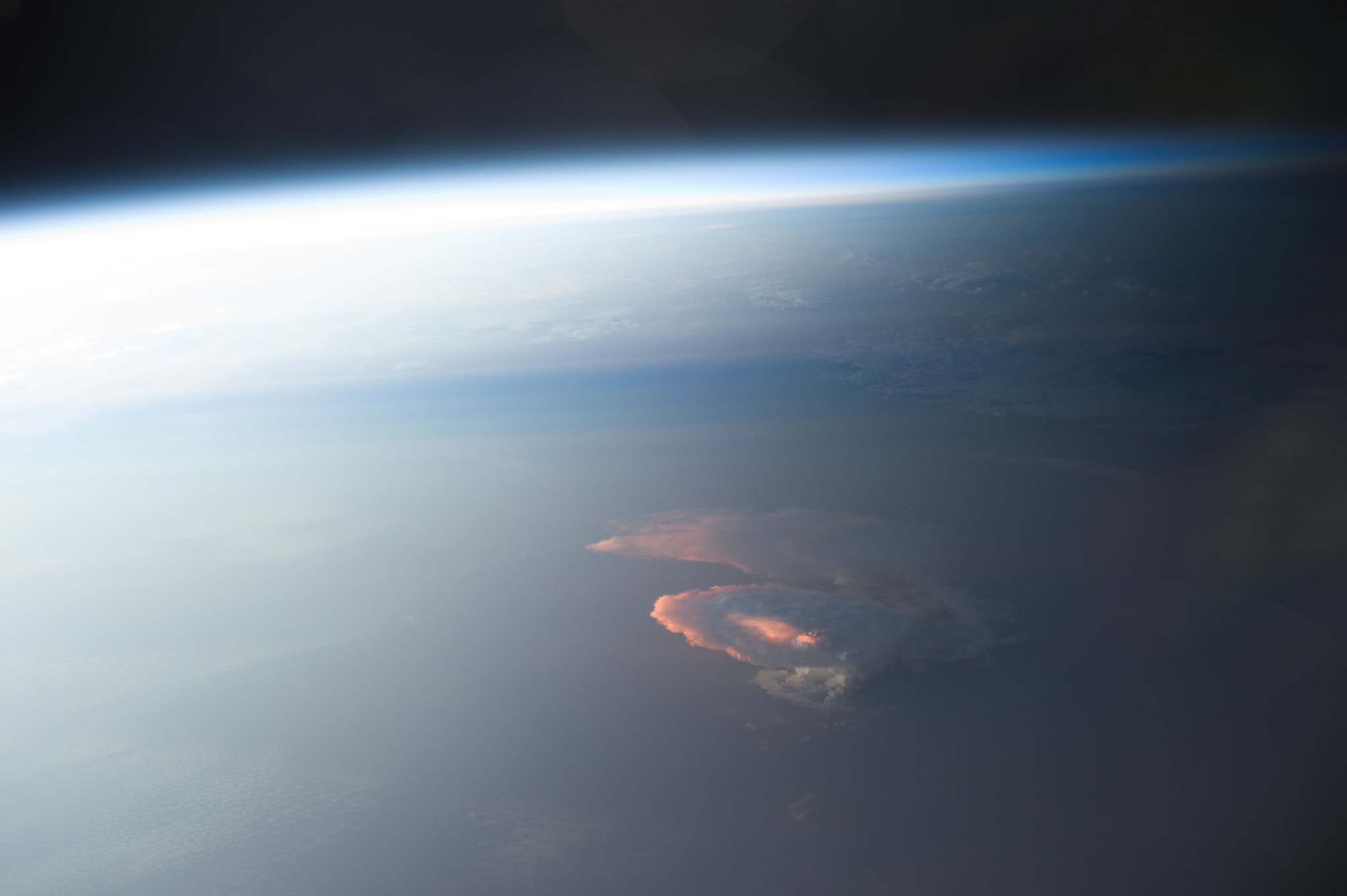 Earth Observation taken during a day pass by the Expedition 40 crew aboard the International Space Station (ISS). Folder lists this as: Afterglow on clouds. Also sent as Twitter message: Sun highlights a storm from underneath.
