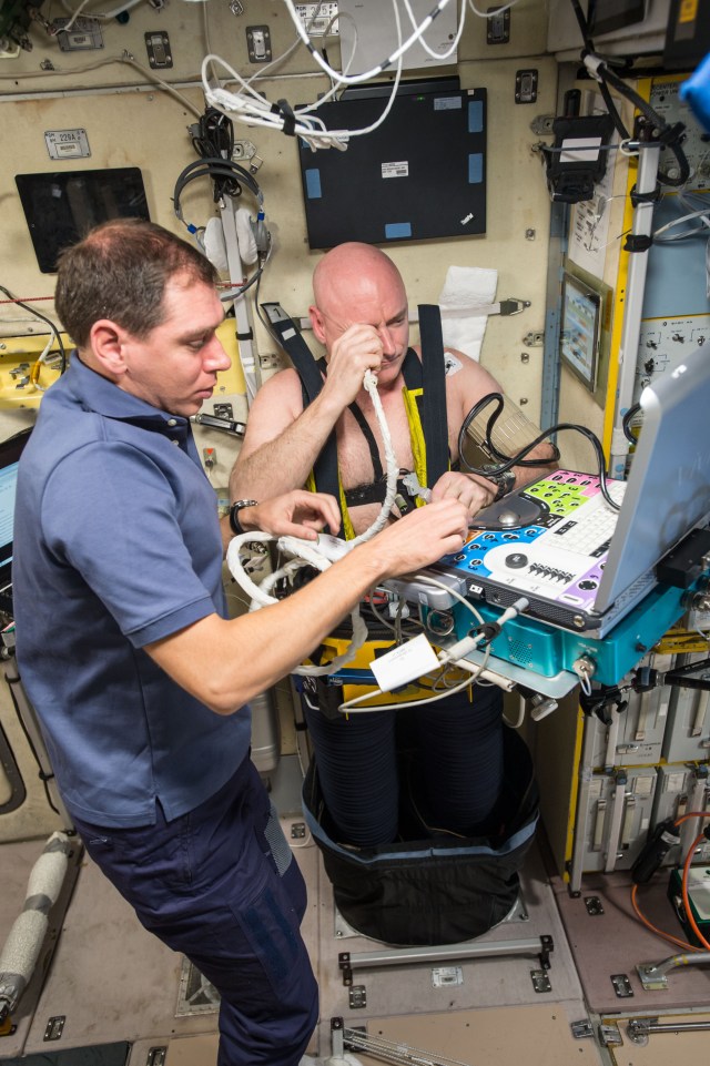 Retired astronaut Scott Kelly, wearing a Chibis Lower Body Negative Pressure (LBNP) Suit, undergoes ultrasound measurements for the Fluid Shifts experiment. He is assisted by flight engineer Sergey Volkov.