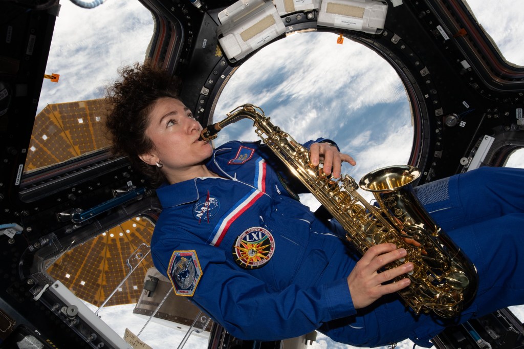 NASA astronaut Jessica Meir plays the saxophone 250 miles above Earth in the International Space Station's cupola.